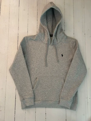 Ralph Lauren hoodie herr, storlek M - Hej! Säljer denna riktigt schyssta hoodie från Ralph Lauren. Den är i storlek L men sitter en storlek litet och passar därför som en M. Den är endast använd någon enstaka gång och är därmed i ett nyskick. Original lappar och påse finns kvar och medföljer naturligtvis vid köp. Jag fraktar alltid snabbt! Mvh