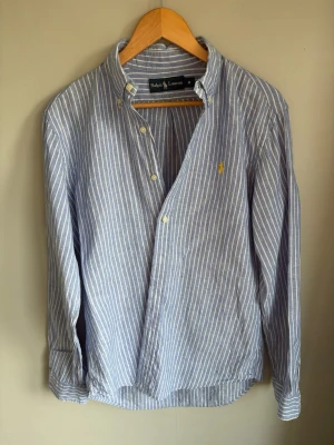 Blårandig linneskjorta från Ralph Lauren - Snygg blårandig skjorta från Ralph Lauren i Linne. Perfekt för de lite mer varmare vädret eller om du bara vill klä upp dig! Skick 10/10 storlek: M                                   Hör av er vid minsta fundering!                                                //Ville
