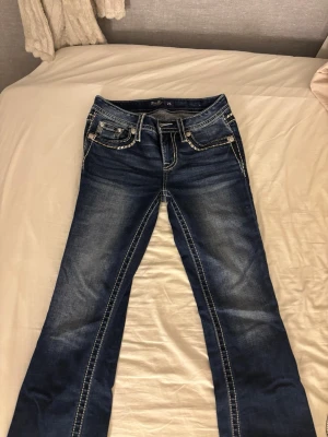 Mörkblå bootcut jeans från Miss Me - Snygga mörkblå bootcut jeans från Miss Me med kontrastsömmar och slitningar. Säljer för dom är för stora för mig och då inte går till användning. Dom är knappt använda, ungefär 5-10 gånger. Klassisk femficksmodell och mid/låg midja. Priset kan diskuteras. Nypris 2200 ungefär.
