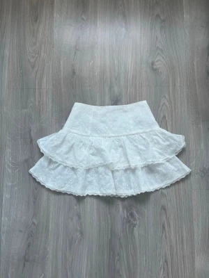 Vit volangkjol🎀🎀 - Söt vit kortkjol med två lager volanger och broderade blommor. Perfekt för sommaren🌺