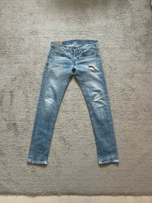 Dondup jeans - Säljer ett par Dondup “George” jeans i storlek 32. Väldigt snygg ljus tvätt med naturlig fade och slitning som ger en riktigt clean look. Slim fit modell som sitter bra på benet. • Modell: George • Märke: Dondup • Storlek: 32 • Nypris: ca 4000 kr Jeansen är i bra skick och har en snygg slitning vid knät som är en del av designen. Perfekta om du vill ha ett par premiumjeans till ett mycket bättre pris. Skriv vid frågor eller intresse! 🙂
