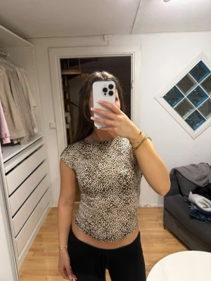 Leopardmönstrad croppad topp - Säljer en leopardmönstrad croppad topp med öppen rygg och korta ärmar. Aldrig kommit till användning, så inga skador eller liknande !