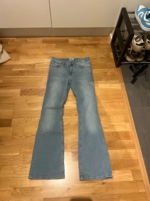 Ljusblå bootcut jeans från 157 - Säljer ett par ljusblå bootcut jeans från 157 med låg midja. Klassisk femficksmodell och snygg tvättad denim. Perfekta för dig som gillar retrovibbar och vill ha ett par jeans med lite vidare ben. Passar till många olika stilar!