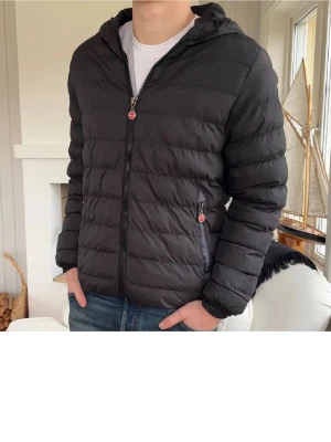 Svart pufferjacka med huva - Säljer en svart pufferjacka med huva och dragkedja framtill. Jackan har två sidofickor med dragkedja och quiltad design. Perfekt när våren nalkas och har en stilren look som passar till det mesta. Öppen för prut, skriv bara om ni har några funderingar😊