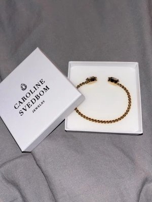 Guldarmband med rosé diamanter Caroline Svedbom - Super snyggt guldarmband med två rose diamanter på. Armbandet är helt nytt aldrig andvänts. Nypris är runt 900kr och mitt pris 700kr. Påse till boxen fås även med. Alla lappar är borttagna men kan visa kvitto vid intresse!hör av er om mer🙌