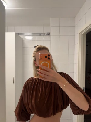 Brun croppad topp från H&M Edition - Säljer en brun croppad topp från H&M Edition med ballongärmar 