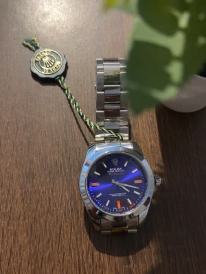 Klocka  - Snygg klocka Milgauss med blå urtavla och orange detaljer. Klockan har ett robust armband i blankpolerat stål och klassisk rund form. Perfekt accessoar för dig som vill sticka ut med stilren och exklusiv design.