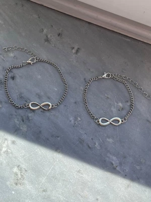 Armband med evighetstecken - Två silverfärgade armband med evighetstecken, säljs tillsammans. Det ena är lite mindre än det andra💕