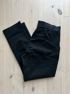 Kostymbyxor - H&M - Svarta kostymbyxor från H&M. Storlek 34. Midjemått ca 36cm, längd ca 87cm, innerbenslängd ca 62cm. Resåren lite sliten på sidan, se sista bilden, i övrigt i fint skick! 🌸