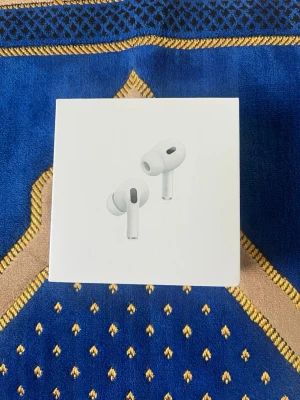 Apple AirPods Pro 2 trådlösa hörlurar - Säljer ett par vita Apple AirPods Pro 2 med stilren design och silikonproppar för bästa passform. Hörlurarna är trådlösa och levereras i originalförpackning. Perfekta för musik, samtal och träning med aktiv brusreducering och smidig laddning.