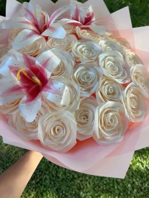Bukett med vita rosor och liljor - 7 blommor (EJ MIN BILD)  - Säljer en vacker bukett med vita rosor och tre stora liljor med rosa inslag. Blommorna är omsorgsfullt arrangerade i ett ljusrosa papper. Perfekt som present eller dekoration till speciella tillfällen. 