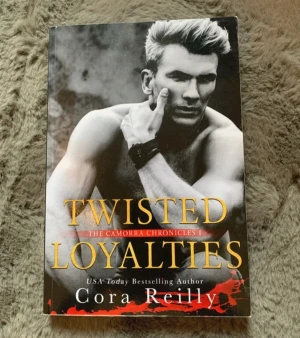 Twisted Loyalties av Cora Reilly - En spännande pocketbok, 'Twisted Loyalties' av Cora Reilly, första delen i The Camorra Chronicles. Omslaget är svartvitt med en porträttbild och titeln i gul text. Perfekt för dig som gillar romantisk spänning och maffiateman.