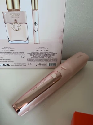 Rosa hårstyler från Beurer split ender - Säljer en snygg och smidig hårstyler från Beurer i metallicrosa plast. Perfekt för att fixa håret snabbt och enkelt. Den har en modern design med vita knappar och borstliknande insida för styling. Passar dig som vill ha ett fräscht hårverktyg i badrummet.