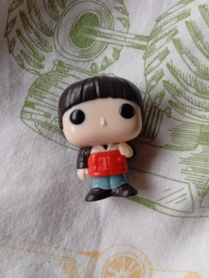 Pop vinyl figur med röd jacka - Säljer en Pop vinyl figur med svart hår, stor huvudform och stora svarta ögon. Figuren har en röd jacka, blå byxor och bruna skor. Perfekt för samlare eller som dekoration i hyllan.