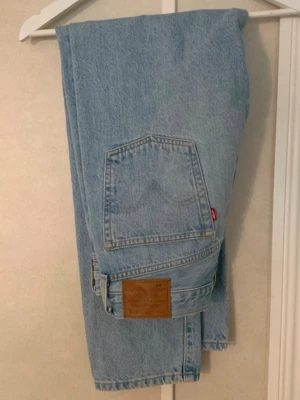 Ljusblå Levi's jeans W32 L28 - Säljer ett par klassiska ljusblå Levi's jeans med rak passform. Tillverkade i 100% bomull för en autentisk denimkänsla.