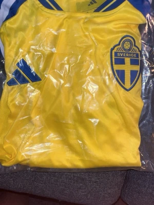 Ny sverige tröja - Säljer en sverige(hemma) tröja då jag fick hem den från en tävling, och har redan dessvärre en sverige tröja. har öppnat och kollat om där är något nummer, eller spelar namn men det är det ej. 