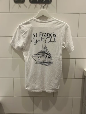 Vit T-shirt med tryck  - Vit T-shirt med ett snyggt svart tryck Storlek: Xs Passform: Normal Skick: Acceptabelt, några gulaktiga fläckar, de syns dock knappt vid användning Märke: Laidbclothing Skickas inom 24h