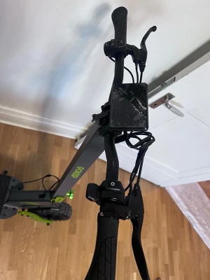 Svart och grön elscooter GO KEEP - Säljer en svart och grön elscooter av modellen GO KEEP. Scootern har robusta däck, stötdämpare bak, bred fotplatta med halkskydd och digital display på styret. Perfekt för smidig transport i stan eller till skolan.