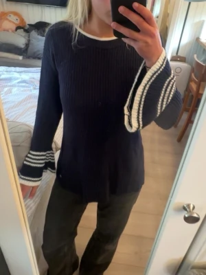 Marinblå stickad tröja  - Mysig marinblå stickad tröja med vuda armar! Använd fåtal gånger, i mycket bra skick! Från Tommy Hilfiger, storlek S!