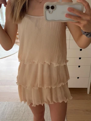 Plisserad beige kortklänning - Otroligt fin klänning som passar till sommarens alla höjdpunkter😍slutsåld på HM & väl eftertraktad, fint skick❣️