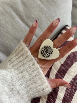 Ring med knapp  - Säljer denna handgjorda ring.  Knapparna är vintage men själva ringen/ringstommen är helt ny och oanvänd. Materialet är rostfritt stål och varken tappar färg eller färgar av sig på huden. Ringen tål vatten. Storleken är justerbar, man kan trycka ihop och dra isär ringen till önskad storlek. Perfekt för dig som vill bära något unikt!