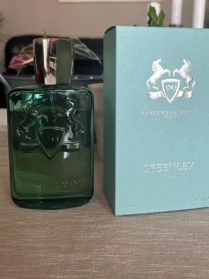Parfums de Marly Greenley EdP 120ml - Greenley från Parfums de Marly är en exklusiv Eau de Parfum i en elegant grön glasflaska med silverfärgat lock. Flaskan har ett stilrent reliefmönster med två hästar och märkets logotyp. Kommer i matchande grön kartong med silverdetaljer.