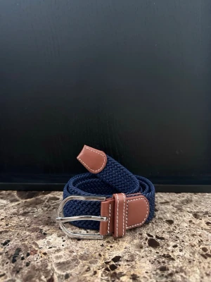 Mörkblått flätat bälte - Tja jag säljer ett mycket fint flätat skärp. Det är helt nytt och är ca 105-110cm och 3,5cm bret, men kan bli mycket längre pga det elastiska materialet. Det finns flera skärp i min profil om du skulle vara sugen och desto mer du köper desto billigare blir det.