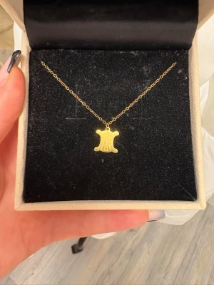 Guldhalsband med unik berlock K18 - Snyggt halsband i 18K guld med Celine märket. Märkt med K18 för äkthet.