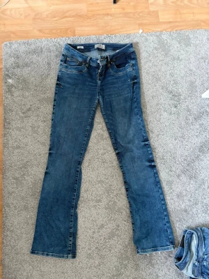 Blå bootcut jeans från LTB - Säljer ett par klassiska blå bootcut jeans från LTB, modell Valerie. Jeansen har små defekter (bild 2) men inget som syns när man har på sig de. Nypris är 900.