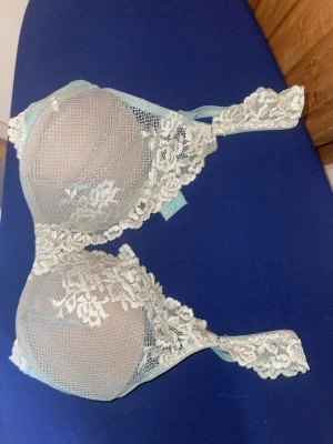 Intimissimi bh - Säljer en ljusblå bh med vacker spets och blommönster. Bh:n har vadderade kupor och breda spetsband som ger en romantisk känsla. Materialet är mjukt och följsamt, perfekt för dig som gillar detaljer och en feminin look. Intimissimi bh i storlek 75b
