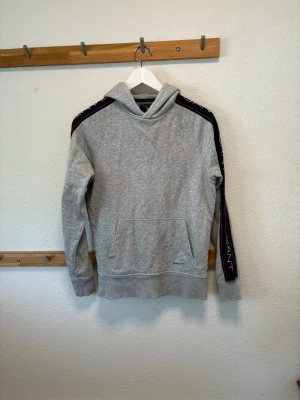 Gant Hoodie - Grå Gant Hoodie i storlek xs. Köpt av mig för 1200kr och väldigt lite använd. Perfekt till svalare sommarkvällar. 