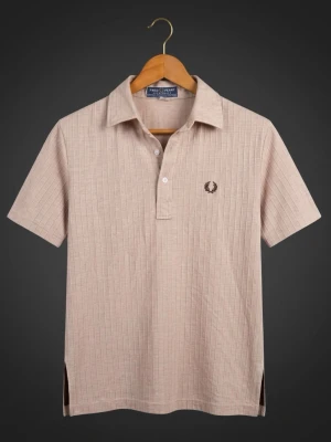 Beige piké från Fred Perry - Snygg beige pikétröja från Fred Perry med diskret randigt mönster och klassisk krage. Tröjan har korta ärmar, knappar framtill och den ikoniska Fred Perry-loggan broderad på bröstet. Perfekt till jeans eller shorts för en clean look.