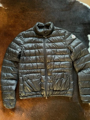 Moncler jacka - Snygg svart dunjacka från Moncler. Köpte jackan i vintras men endast använd 2-3 gånger. Superbra skick! Kan tänka mig att gå ned i pris vid snabb affär💕