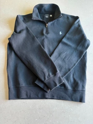 Svart half-zip från Polo Ralph  - Säljer en svart halfzip från Ralph Lauren I fint skick, nypris ligger runt 2200kr. Tröjan är snygg och stilren och passar perfekt till sommarkvällar eller en kyligare dag!☀️Hör av dig vid funderingar! (Pris går att diskutera)