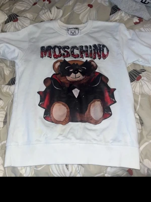 Vit Moschino tröja S - Cool vit tröja från Moschino med ett stort tryck av en björn i maskeradkostym. Storlek S oanvänd