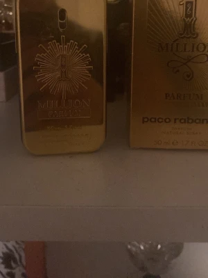 Paco Rabanne 1 Million Parfum 50ml - 1 Million Parfum från Paco Rabanne i en lyxig guldfärgad flaska med unik rektangulär form och detaljerad solstråle-design. Doften kommer i en matchande guldfärgad kartong och rymmer 50 ml. Perfekt för dig som gillar exklusiva och intensiva parfymer.