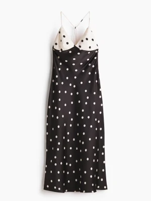 Svartvit prickig långklänning (nypris 499kr) - Säljer en svart långklänning med vita prickar och tunna axelband. Överdelen är vit med svarta prickar och har en v-ringad skärning. Klänningen har en flowy passform och är tillverkad i ett glansigt material som liknar satin. (Säljer då jag inte längre kan returnera den)
