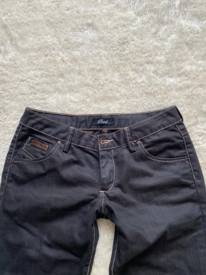 Svarta jeans från Phard - Säljer ett par svarta jeans från PHJ med snygga kontrastsömmar och klassisk femficksmodell. Jeansen har en läderpatch med PHJ-logga bak i midjan och utsvängda ben. Perfekta för dig som gillar stilrena och tidlösa jeans. Midjan rakt över: 38cm Innerben:84cm