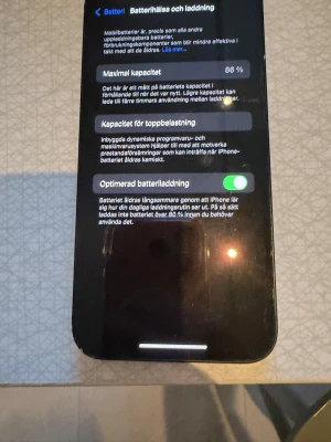 Svart iPhone med dubbla kameror - Snygg svart iPhone med två bakre kameror och stilren glasbaksida. Klassisk Apple-design med rundade hörn och tydlig logotyp på baksidan. Perfekt för dig som gillar modern teknik och vill ha en pålitlig smartphone.