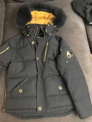 Svart dunjacka från Moose Knuckles - Svart guldig moose knuckles jacka söker efter byten med moose knuckles bunny eller säljs för 1800