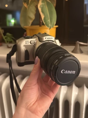 Canon eos IX7, analog kamera, 35mm - Säljer min fina gamla Canon då jag har för många kameror i hyllorna. Superfint skick, 28-80mm objektiv som jag köpt en uv-lins till. Jag har använt den så jag vet att den fungerar, men jag lämnar ingen garanti. Nya batterier behövs, men det är batterier som fortfarande finns att köpa för en billig peng på typ Clas Ohlson (2st CR2). Ren och fin invändigt och utvändigt, tar väldigt fina bilder. 