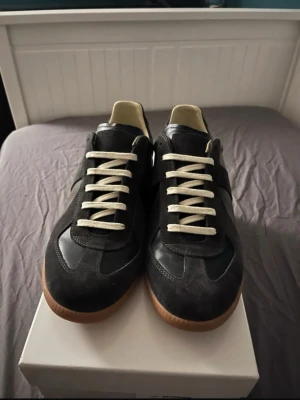 Maison Margiela Replica sneakers svart - Säljer ett par Svarta Maison Margiela i nytt skick i storlek 42 och är perfekt för dig som vill ha en avslappnad stil