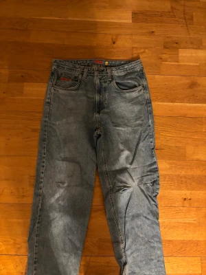 Blå raka jeans från EMPYRE  - Säljer ett par klassiska blå jeans från EMPYRE  med rak passform och fem fickor. Jeansen har en vintage look och är tillverkade i slitstark denim. Perfekta för dig som gillar en tidlös och avslappnad stil.