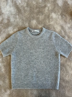 Grå stickad t-shirt från ZARA - Supersnygg kortärmad stickad tröja från Zara. Inte använd så mycket!