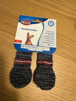 Hund tossar 2 st - Hund tossar 2 st. Trixie Non-Slip Hundsockar ger hunden extra grepp och skydd. Dessa hundsockar i storlek XS-S passar för små tassar. De grå sockarna är designade för att minska halkrisken på hala golv och skydda tassarna både inomhus och utomhus. Det slitstarka materialet är bekvämt att bära och sitter säkert på plats. Förpackningen innehåller 2 stycken sockor som är lätta att ta av och på. Tillverkade av bomull och har halkfria pluppar på sulorna för att ge bra grepp på hala ytor.