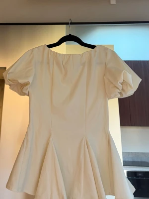 Nakd - Vit topp - Säljer en söt vit blus med puffiga korta ärmar och volang nedtill. Aldrig använd. 