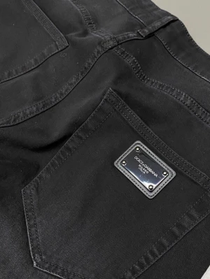 Svarta jeans från Dolce & Gabbana - Snygga svarta jeans från Dolce & Gabbana med klassisk femficksmodell och metallpatch på bakfickan. Jeansen har raka ben och är tillverkade i ett mjukt, slitstarkt material som ger en clean och stilren look.