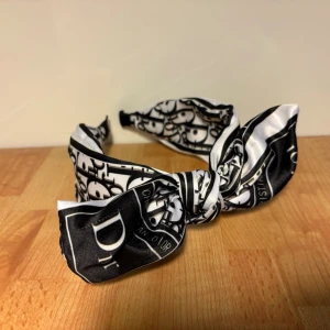 Diadem - Svart/vitt diadem. Justerbar rosett som man även ska kunna ta bort. Är ungefär 6 cm där det är som bredast. Aldrig använt!