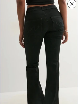 Svarta bootcut jeans med fickdetalj - Säljer ett par svarta bootcut jeans med snygga sömmar på bakfickorna. Byxorna är ifrån Nelly i storlek 34/short. Prislappen är kvar och dom är endast testade. Säljer pga av att dom va för små för mig! Pris går att diskutera 