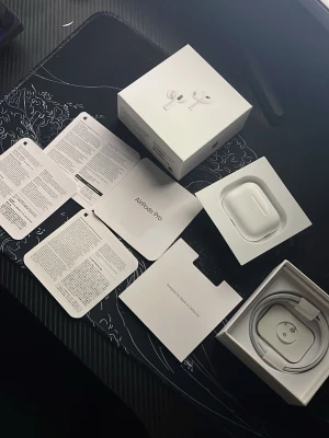 Apple AirPods Pro med laddningsetui - Säljer ett par Apple AirPods Pro med vitt laddningsetui och originalförpackning. Hörlurarna är trådlösa och har silikonproppar för optimal passform. Medföljer även USB-C laddningskabel och manualer. Perfekt för dig som vill ha grymt ljud och brusreducering.